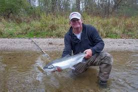 Kevin Feenstra started Feenstra Guide Service LLC in 1997.     He has spent countless hours on the Muskegon River, and still fishes the river system and surrounding waterways every chance he can.     His passion is swinging flies for steelhead, but loves to fish for any predator fish that is willing to eat a fly.    Year after year, Kevin guides the Muskegon River for hundreds of days and still loves it.   He is a licensed USCG captain.

In addition to guiding, Kevin is an active writer and fly tier.    His most recent project is a book, Matching Baitfish, which was published in November 2020.     He has also published several fly fishing DVDS, including Searching for Steelhead, Striking Steel,and Big Appetite, Small mouth.    He has authored many magazine articles, and his flies are published in fly tying manuals and magazines.  Kevin frequently speaks at fishing shows and clubs throughout the Midwest.

Kevin has one other passion, outdoor photography, where he hopes to capture the beauty and majesty of West Michigan both above and below the water.  He resides in Newaygo, Michigan, with his lovely wife and three children.